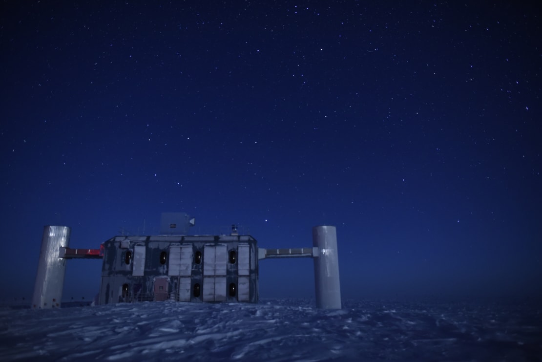 The IceCube Lab in winter, with dark bluish sky and stars.