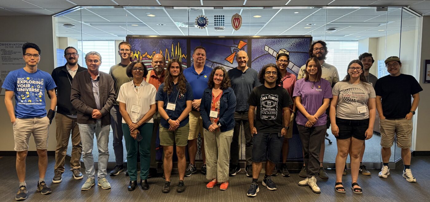 A group of people posing in front of an art mural.