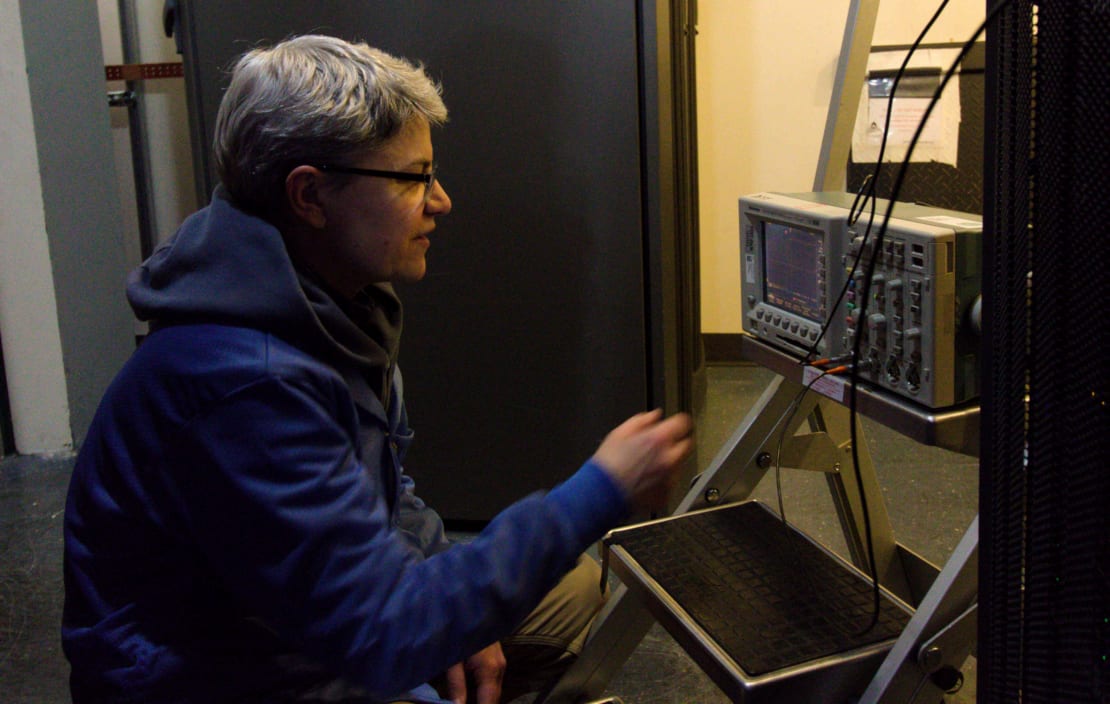 Close-up of someone from the side as they sit in front of oscilloscope.